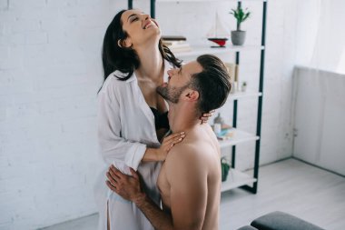 gömlek gülümseyen ve esmer kadın gömleksiz adam ile sarılma 