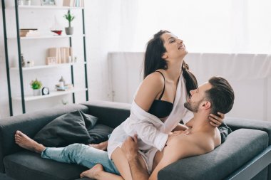 sutyen esmer ve gülümseyen kadın ile gömleksiz ve yakışıklı adam sarılmak 