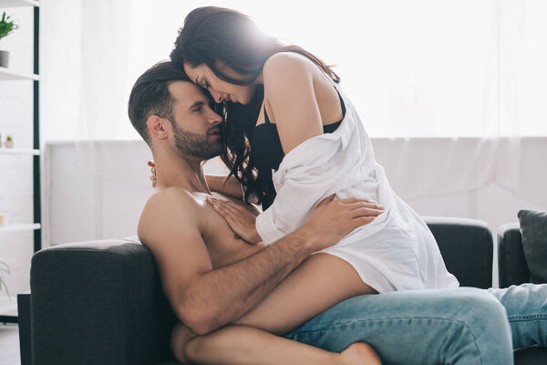 shirtless and handsome man kissing and hugging with brunette woman 