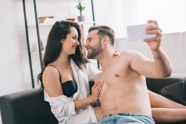 yakışıklı adam ve gömlek ve sutyen birbirlerine bakarak ve selfie alarak seksi kadın 