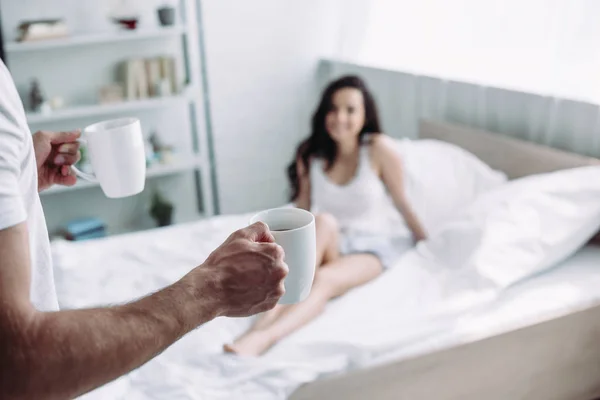 Selective Focus Man Holding Cups Tea Woman Sitting Bed — Stock Photo, Image