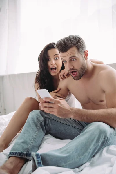 Geschokt Mooie Vrouw Knappe Man Zoek Naar Smartphone — Stockfoto