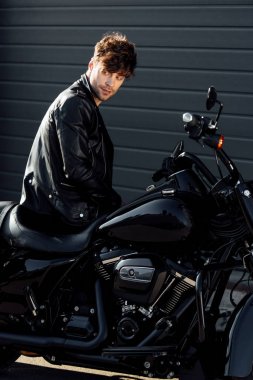 motosiklet üzerinde oturan siyah deri ceket genç motosikletçi 