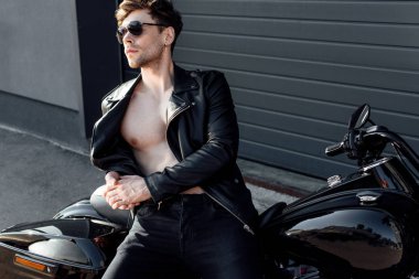 deri kaslı genç adam motosiklet yaslanmış jacked