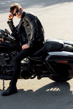 gömleksiz motosiklet dışında duran ve uzağa bakan tam uzunlukta görünümü