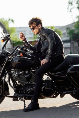 motosiklet üzerinde oturan güneş gözlüğü ve deri ceket motosikletli yan görünümü
