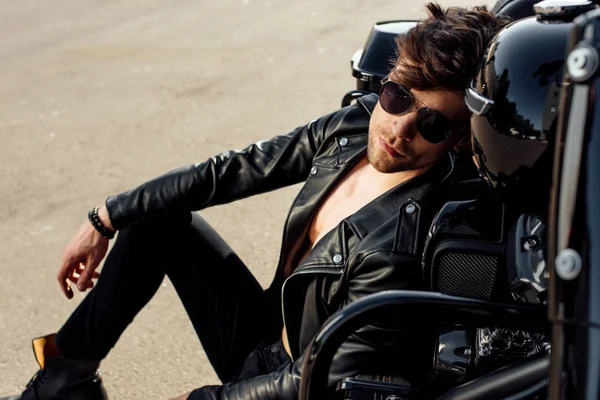 Красивий Молодий Чоловік Сонцезахисних Окулярах Спирається Мотоцикл Сидячи Землі — стокове фото