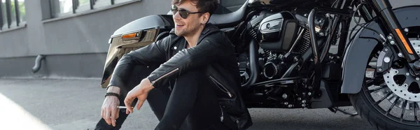 Панорамний Знімок Молодого Чоловіка Сидить Біля Чорного Мотоцикла Посміхається Тримає — стокове фото