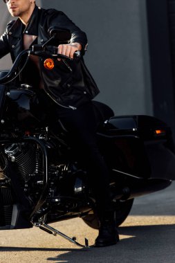 siyah motosiklet üzerinde oturan motosikletçi kırpılmış görünümü 