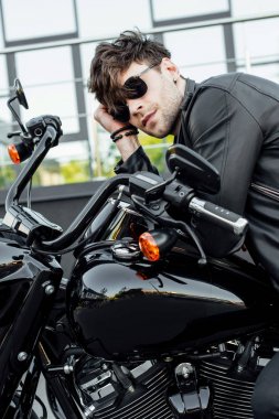 motosiklet üzerinde otururken deri ceket dinleniyor yakışıklı genç adam 