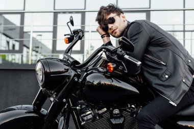 yeni siyah motosiklet üzerinde otururken deri ceket dinleniyor yakışıklı genç adam 