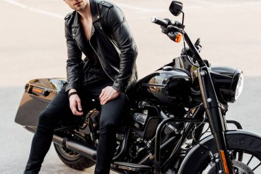 cropped view of shirtless motorcyclist sitting on motorcycle outside  clipart