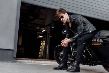 açılan garaj yakınında oturan motosiklet üzerinde oturan yakışıklı genç adam 