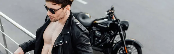 오토바이에서 울타리에 기대어 몸통을 재킷을 남자의 파노라마 — 스톡 사진