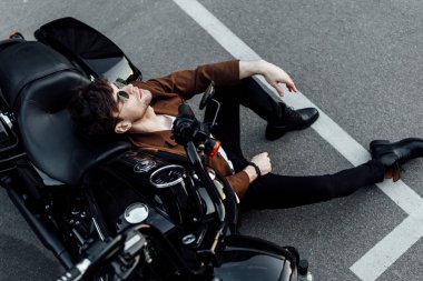 balck motosiklet yaslanmış ve alphalt otururken dinlenen adam üst görünümü