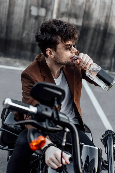 Foco Seletivo Homem Bonito Beber Álcool Enquanto Sentado Motocicleta — Fotografia de Stock