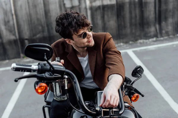 Young Man Sunglasses Holding Bottle Sitting Motorcycle Looking Away — Stock Photo, Image