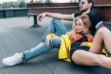 kapalı gözleri ve gözlüklü yakışıklı adam çatıda oturan çekici kadın 