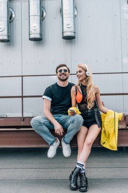 akıllı telefon ve adam ile gülümseyen kullanarak kulaklıklar ile çekici ve sarışın kadın 