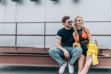 akıllı telefon kullanarak ve adam ile uzak görünümlü kulaklıklar ile çekici ve sarışın kadın 