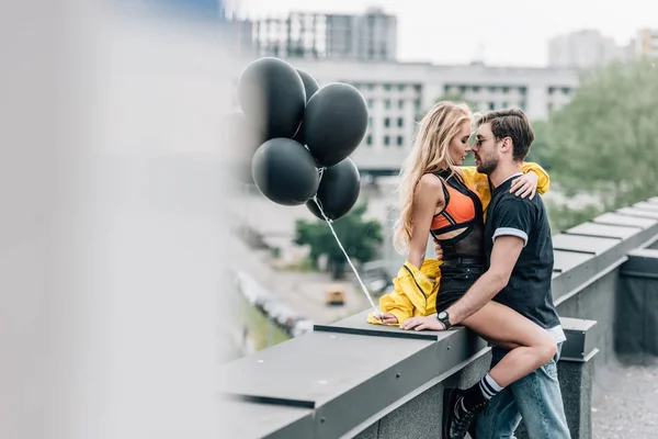 Foco Seletivo Mulher Atraente Segurando Balões Pretos Abraçando Com Homem — Fotografia de Stock