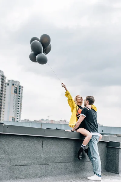 Mulher Atraente Segurando Balões Pretos Abraçando Com Homem — Fotografia de Stock