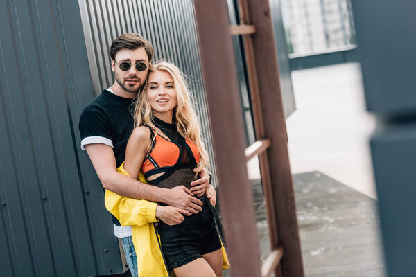 attractive woman and handsome man hugging and looking at camera 