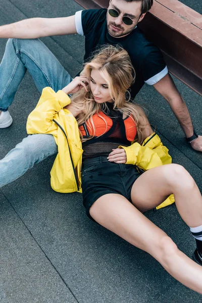 Çatıda oturan gözlük çekici kadın ve yakışıklı adam yüksek açı görünümü 