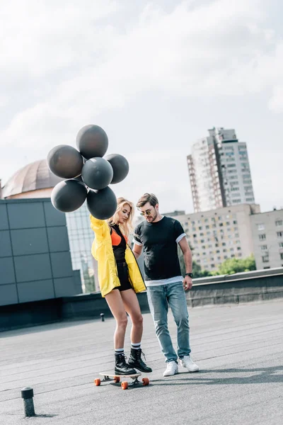 Attraktiv Kvinna Med Ballonger Skateboard Och Man Glasögon Stående Med — Stockfoto