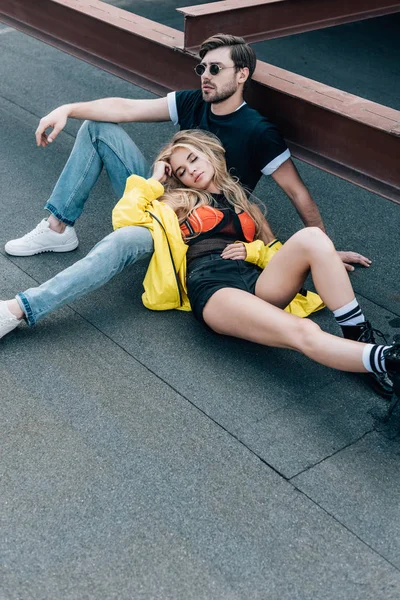 kapalı gözleri ve gözlüklü yakışıklı adam çatıda oturan çekici kadın 