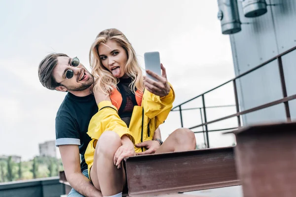 Attractive Blonde Woman Sticking Out Tongue Taking Selfie Handsome Man — Stock Photo, Image