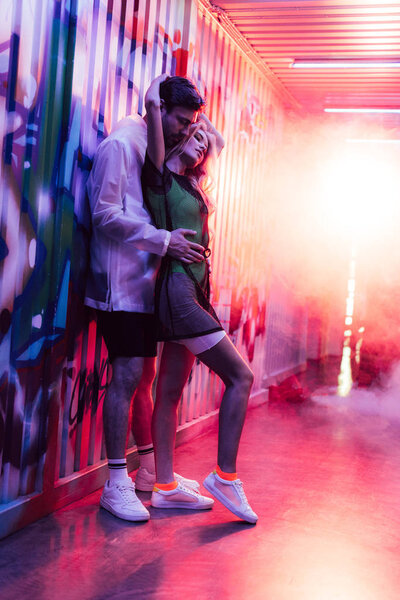 привлекательная блондинка обнимается с красивым мужчиной в ночном клубе
