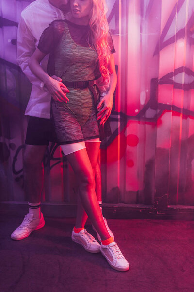 обрезанный вид женщины, обнимающейся с мужчиной в ночном клубе
