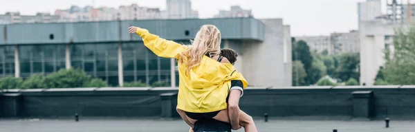 屋根の上で男と遊ぶブロンドの女性のバックビュー — ストック写真