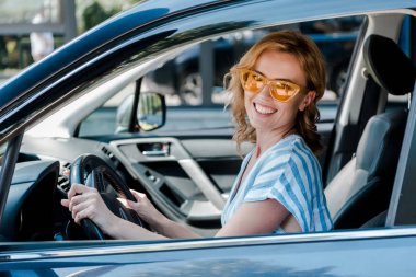 arabada otururken direksiyon tutan güneş gözlüğü mutlu sarışın kadın 