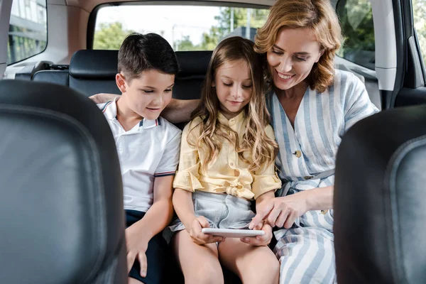 Selective Focus Cheerful Mother Pointing Finger Smartphone Kids Car — Stock Photo, Image