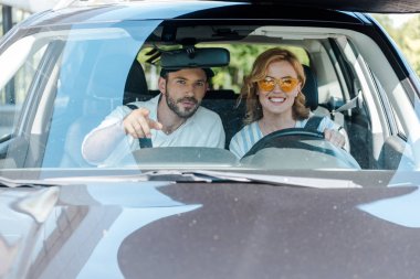 kadın araba sürerken parmakla işaret adam seçici odak 
