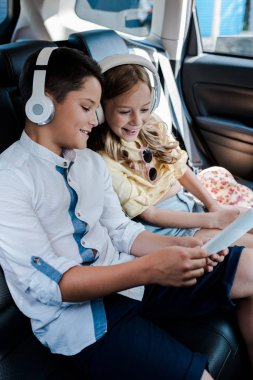 arabada akıllı telefon bakarken kulaklık müzik dinleneşeli çocukların seçici odak 