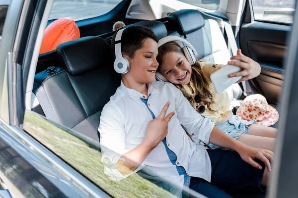 Selective Focus Happy Sister Taking Selfie Brother Showing Peace Sign — Stock Photo, Image