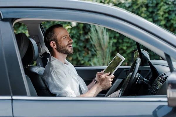 Szczęśliwy Brodaty Człowiek Siedzi Samochodzie Pomocą Cyfrowego Tabletu — Zdjęcie stockowe