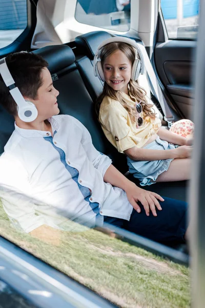 Selektywne Skupienie Szczęśliwych Dzieci Słuchania Muzyki Słuchawkach Siedząc Samochodzie — Zdjęcie stockowe