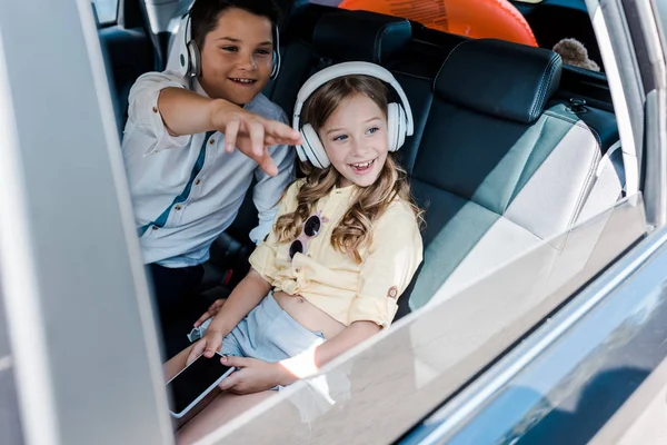 Selective Focus Happy Kid Pointing Finger Sister Headphones — Stock Photo, Image