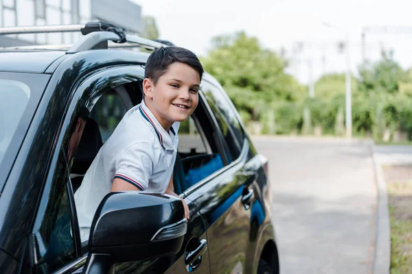 Allegro Ragazzo Sorridente Guardando Fotocamera Dal Finestrino Dell Auto — Foto Stock