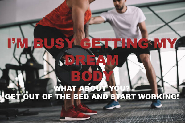 cropped view of trainer standing near african american sportsman lifting barbell near illustration with motivation inscription