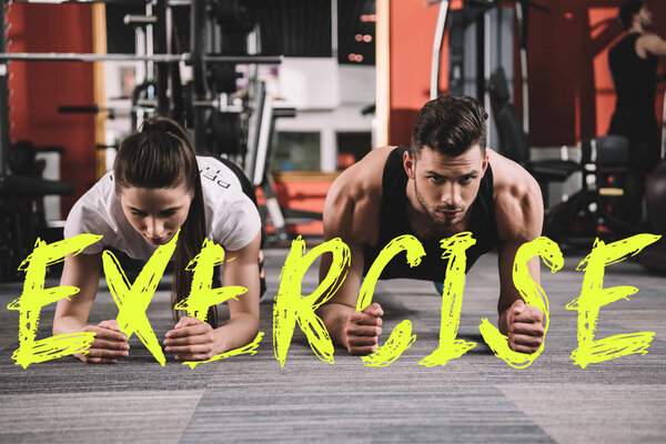 attractive trainer and handsome sportsman doing plank exercise near illustration with exercise inscription