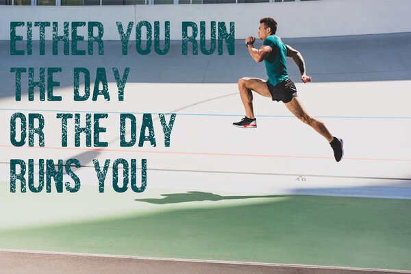 side view of mixed race sportsman running at stadium with either you run the day or the day runs you lettering