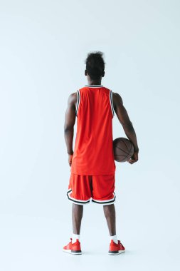 Afrika Amerikan basketbol oyuncusu gri arka planda tutan topu arka görünümü