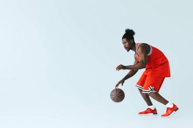 kopya alanı ile gri arka plan üzerinde basketbol oynayan yakışıklı Afrikalı Amerikan sporcu