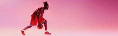 pembe ve mor degrade arka planda basketbol oynayan African American sporcu panoramik çekim 