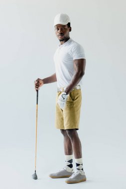 gri arka planda yakışıklı African American sporcu tutan Golf Kulübü